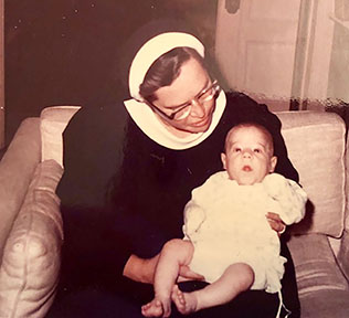 Sr. Alice, in the modified Sisters of Mercy habit, dotes on one of her grand-nieces or nephews.